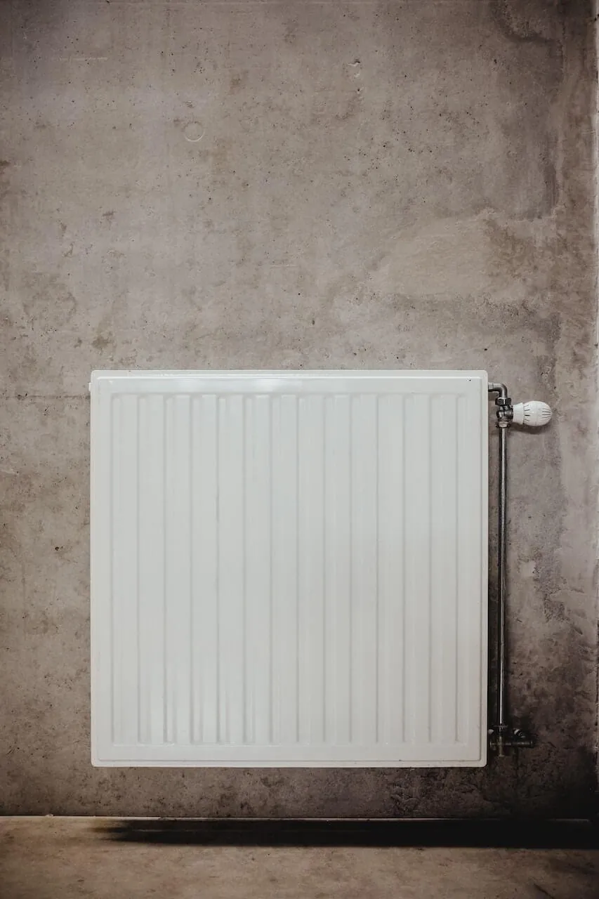 White central heating radiator on a bare concrete wall