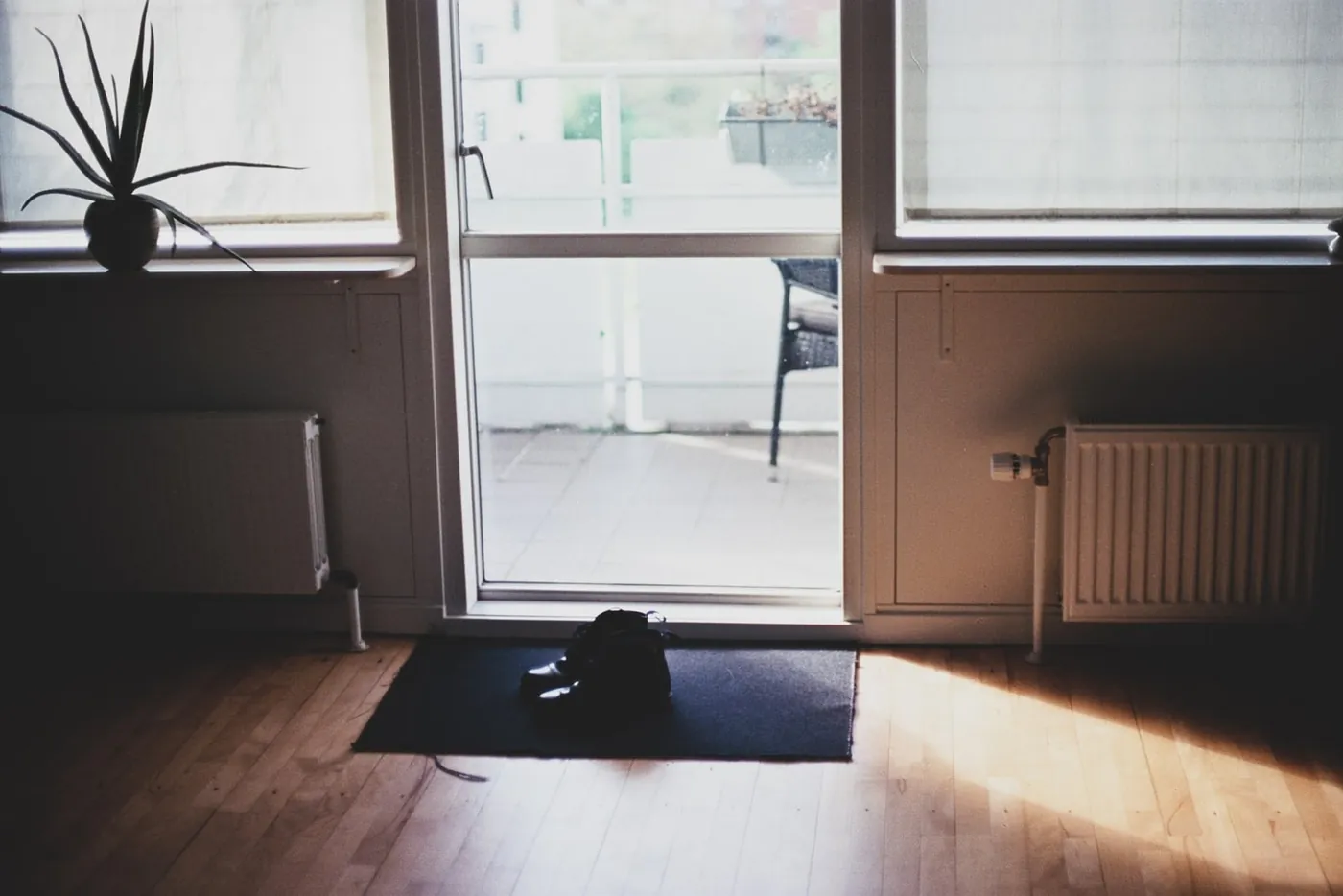Two central heating radiators either side of a glazed balcony door