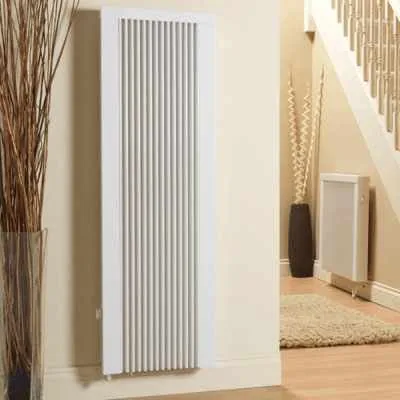 Tall vertical electric radiator in a hallway beside the stairs