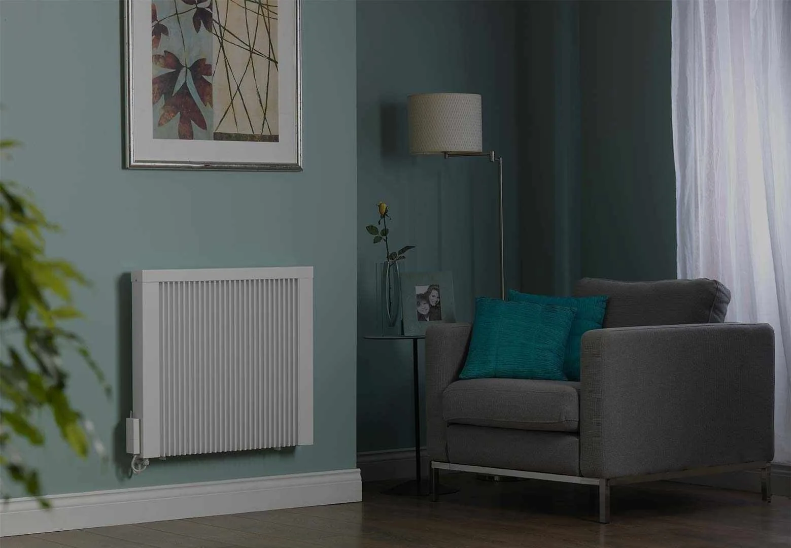 Slim white electric radiator wall-mounted on a teal living room wall
