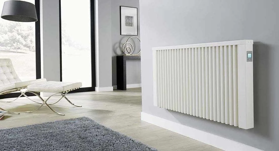 White electric radiator in a modern living room with floor-to-ceiling windows