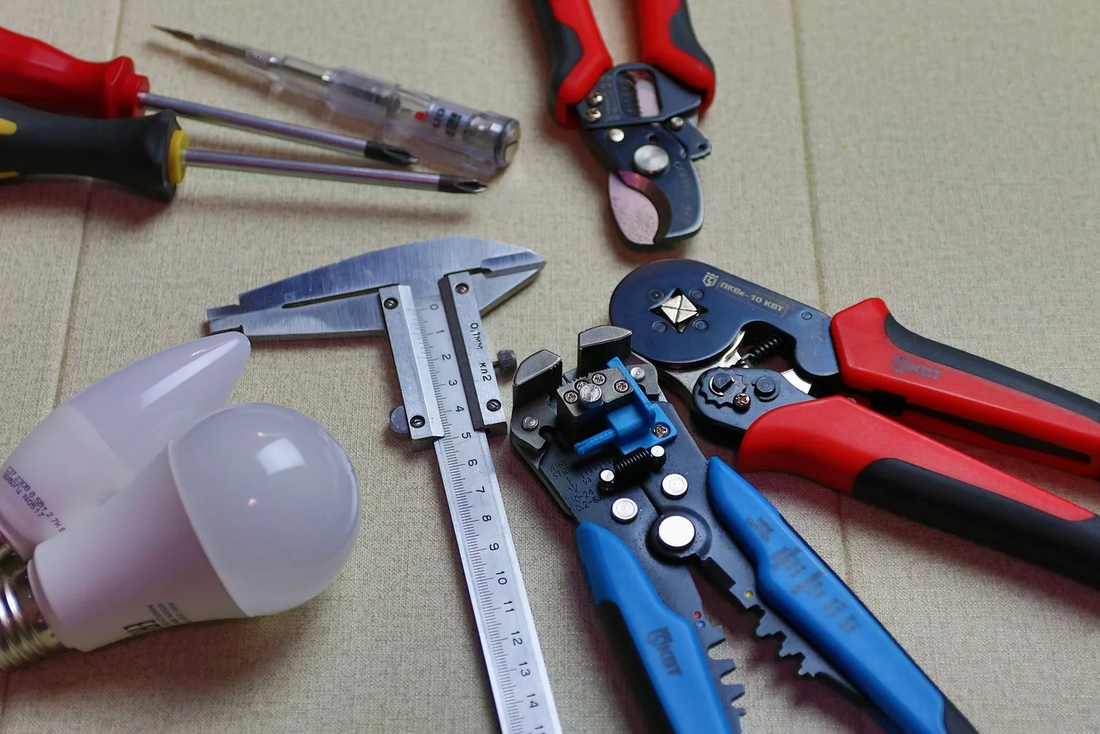 Installer’s hand tools laid out, including crimping pliers, wire strippers and a vernier caliper