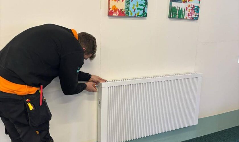 Dynamic Heaters Engineer Installing Electric Radiator In Youth Hall